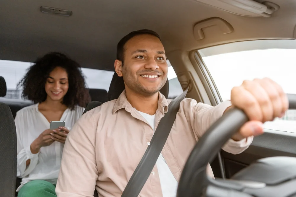 Passageira sorridente em viagem do Ôxe Vai
